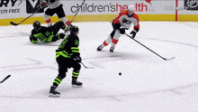 a hockey game is being played in front of a children 's health banner