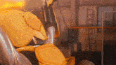 a yellow robot is sitting in a warehouse with a ladder in the background