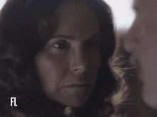 a close up of a woman 's face with the letters fl on the bottom right