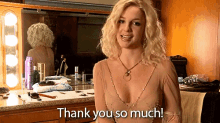 a blonde woman is standing in front of a mirror and says " thank you so much "