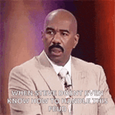 a bald man with a mustache is wearing a suit and tie and talking on a stage .