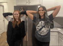 a woman wearing a shirt that says silent planet is standing next to another woman