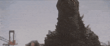 a monster with a bridge in the background is looking at the camera