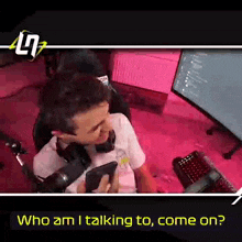 a man sitting in front of a microphone holding a cell phone with the words who am i talking to come on on the bottom
