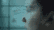 a close up of a person 's face in a dark room with a blue background .