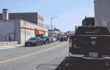 a row of cars are parked on the side of the road in front of a pharmacy