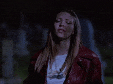 a woman wearing a red leather jacket and a white t-shirt with a dragonfly on it
