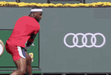 a tennis player is doing a handstand while holding a tennis racket .