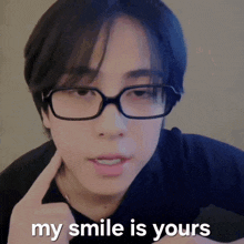 a young man wearing glasses and a black shirt says " my smile is yours "