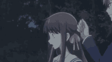 a girl in a blue school uniform is holding her hair and making a funny face .