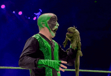 a man with green paint on his face is holding a green glove