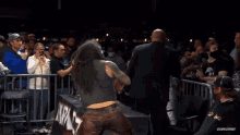 a man with a tattoo on his back is being escorted by a security guard