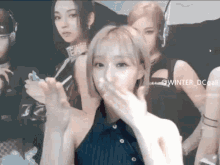 a woman blowing a kiss in front of a group of women