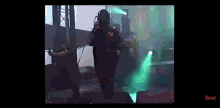 a video of slipknot performing on stage with green lights behind them