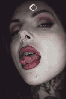 a close up of a woman 's face with red lips and a nose ring