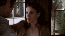a man and a woman are looking at each other in a room