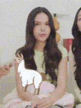 a woman with long hair is sitting next to another woman with a drawing of a llama on her arm