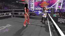a woman is standing in a wrestling ring with a sword in her hand .
