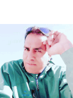 a man wearing sunglasses and a green jacket with the word merida on it