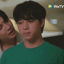 a man in a green shirt is standing next to another man in a white shirt with the wetv logo in the background