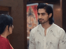 a man in a white shirt is talking to a woman
