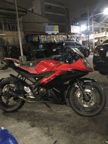 a red and black motorcycle is parked in front of a building with a sign that says ' apollo ' on it