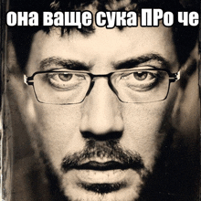 a black and white photo of a man wearing glasses with the caption " она ваще сука "