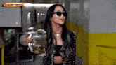 a woman wearing sunglasses is holding a gold object with the words earlier today on the top