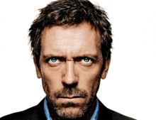 a man with blue eyes and a beard is looking at the camera