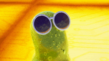 a green cartoon character wearing round sunglasses