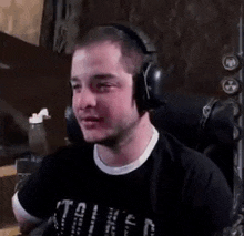 a man wearing headphones is sitting in a chair and making a face .