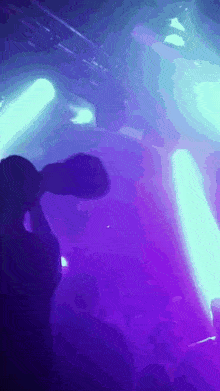 a purple and blue light is shining on a crowd