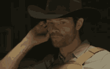 a man wearing a cowboy hat is making a face