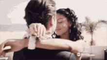 a man and a woman are hugging with a twisted family advertisement behind them