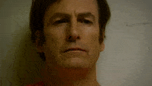 a close up of a man 's face in front of a white board