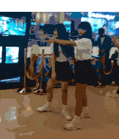 two girls dancing in front of a mcdonald 's sign