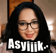 a woman wearing glasses is smiling with the word asylik above her
