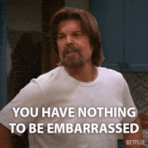 a man with a beard is wearing a white shirt that says you have nothing to be embarrassed on it