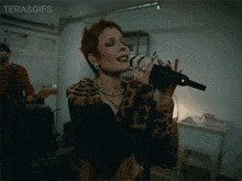 a woman singing into a microphone with the words terasgifs written above her