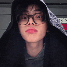 a close up of a person wearing glasses and a black hoodie