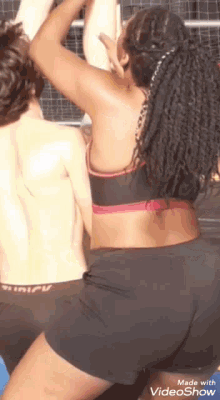 a woman in a sports bra and shorts is standing next to a man in boxer shorts .