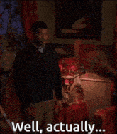 a man standing in a room with the words well actually written on the screen