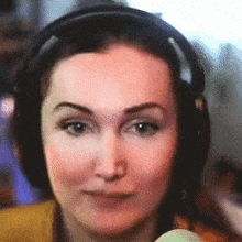 a woman wearing headphones holds a microphone in her hand