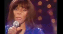 a close up of a woman singing into a microphone .