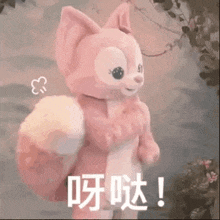 a pink stuffed animal with chinese writing on it is standing in the woods .