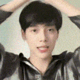 a close up of a young man 's face with his hands in his hair .