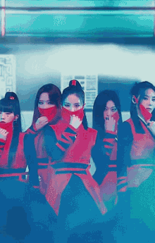 a group of women wearing red and black outfits covering their faces with red masks