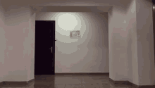 a hallway with a door and a sign on the wall that says emergency exit