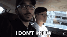 a man in a car says " i don 't know " while another man looks on