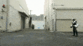 a person in a robot costume is standing in a parking lot in front of a building
